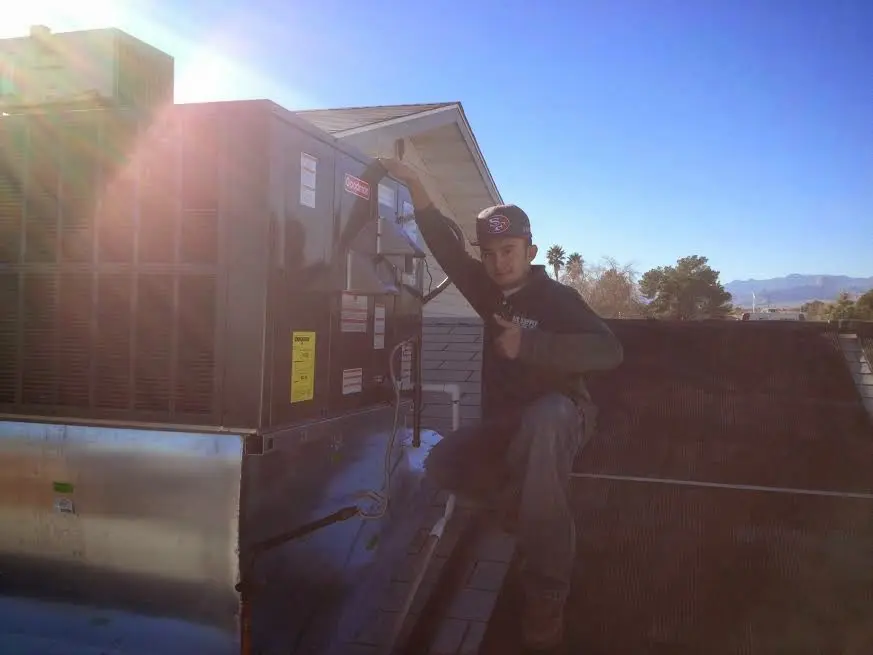 HVAC technician performing AC Tune-Up on a rooftop unit in Niles